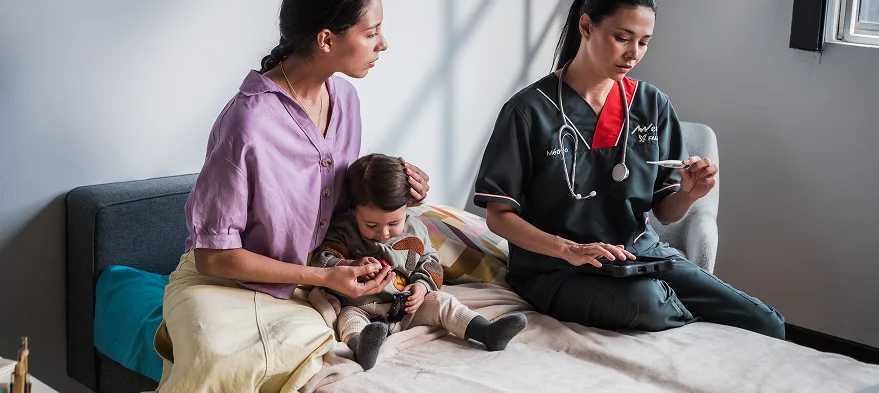 Médico a domicilio EMI para niños y familias Médico de EMI atendiendo a un niño en casa junto a su familia